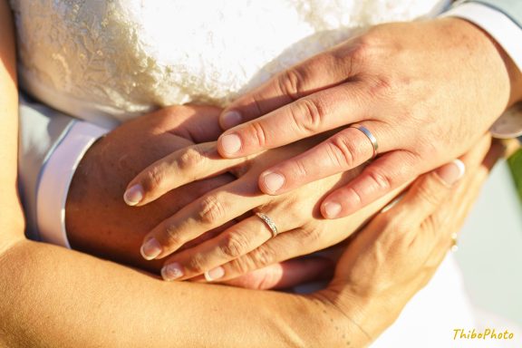 Deux mains entrelacées avec des alliances, symbolisant l'amour et l'engagement.
